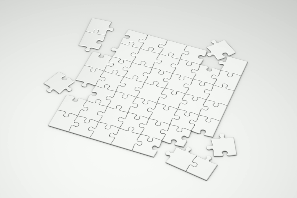 A top view of incomplete white puzzle pieces on a clean, minimalist background.